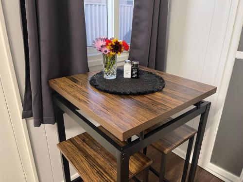 a wooden table with a vase of flowers on it at Wannanup Retreat in Wannanup
