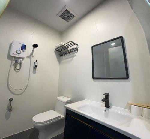 a bathroom with a toilet and a sink and a mirror at Hotel LBS in Kuala Lumpur