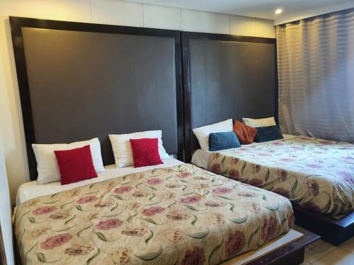 two beds sitting next to each other in a room at Hotel The Grand Inn Complex in Lahore