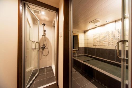 a bathroom with a shower and a walk in shower at Sennentei in Yurihama