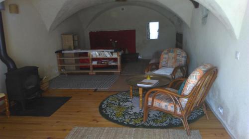 a living room with a table and chairs and a stove at Chez Corban in Rosans