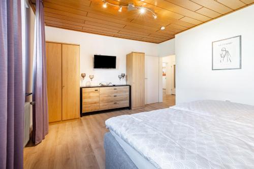 a bedroom with a bed and a flat screen tv at Mama Mia in Platteheide