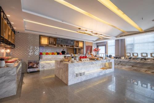 a restaurant with a counter in the middle of a room at Mehood Lestie International Hotel Shenzhen Science and Technology Park Hi-Tech Central Metro Station Branch in Shenzhen