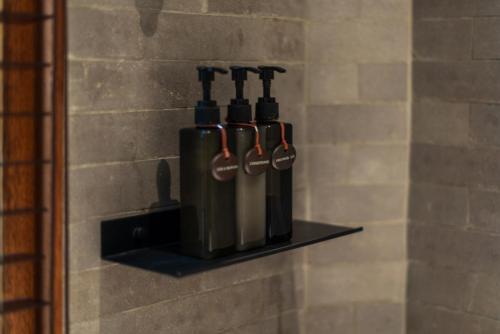 a row of bottles on a shelf on a wall at Na Tanao 1969 in Bangkok