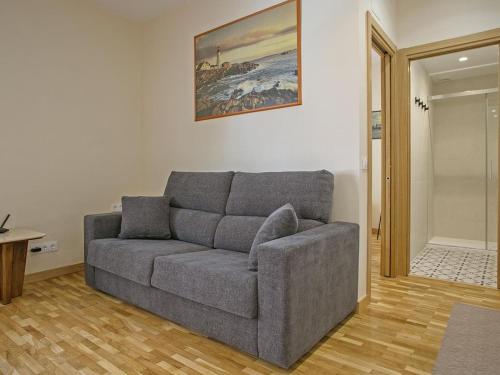 a living room with a couch and a painting on the wall at Winahost Sabadell Buxeda in Sabadell