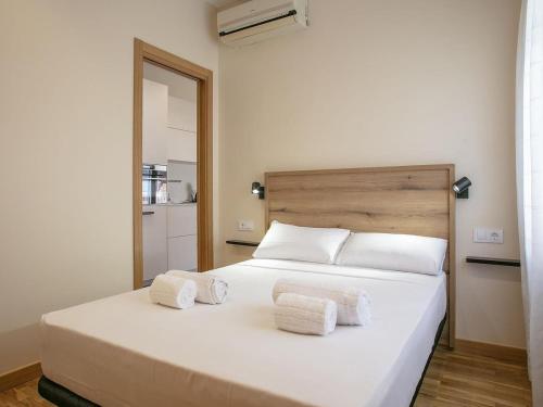 a bedroom with a white bed with towels on it at Winahost Sabadell Buxeda in Sabadell