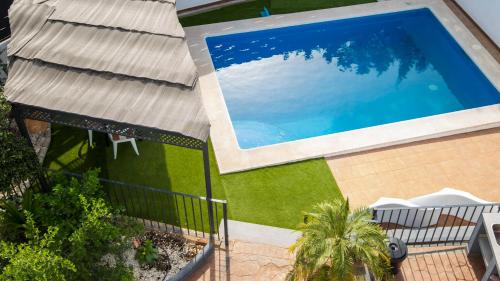 einen Blick über den Pool auf ein Haus in der Unterkunft Villas Del Acebuche in Córdoba