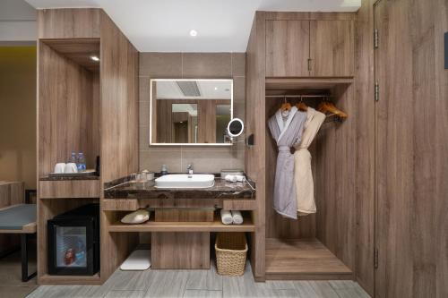 a bathroom with a sink and a mirror at Mehood Lestie International Hotel Shenzhen Science and Technology Park Hi-Tech Central Metro Station Branch in Shenzhen