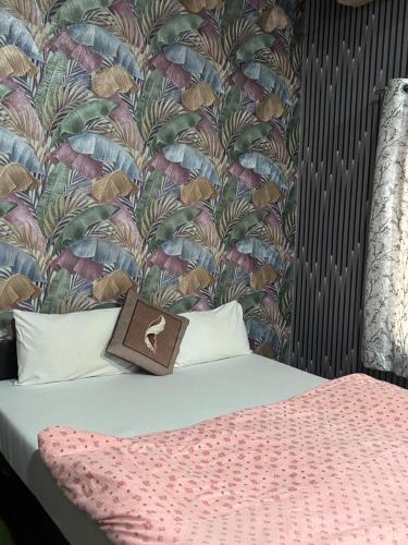 a bed with a purse on top of it with a wallpaper at The Royal Lake View Villa in Udaipur