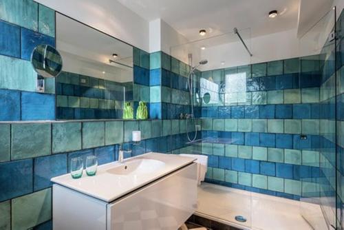 a bathroom with a white sink and blue tiles at Mintrops Stadt Hotel Margarethenhöhe in Essen