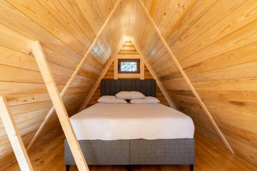 a bed in the middle of a room in a tree house at Wood heaven in Žabljak