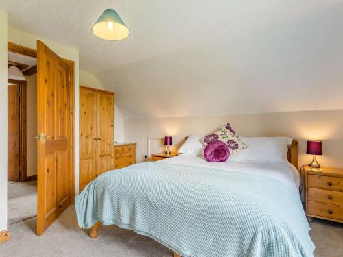a bedroom with a large bed with a purple pillow on it at 3 bed in Worcester CC037 in Clifton upon Teme
