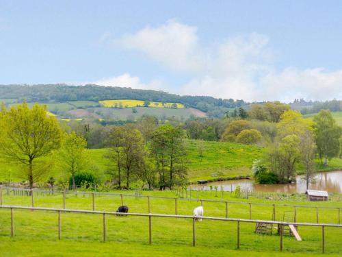 a group of animals grazing in a field next to a river at 3 bed in Worcester CC037 in Clifton upon Teme