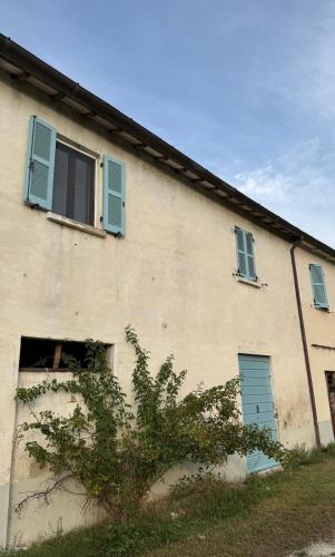 a building with blue shutters on the side of it at Cà CASTIGLIONE in Acqualagna