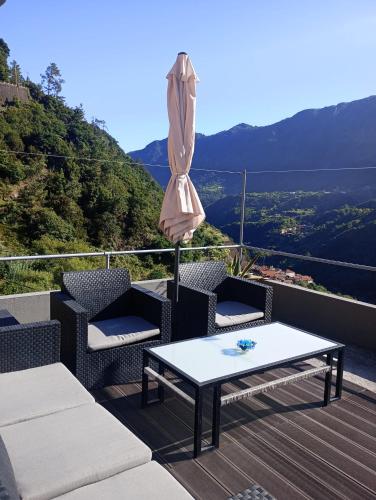 a patio with chairs and a table and an umbrella at Casa Vicente II, By OP in Boaventura