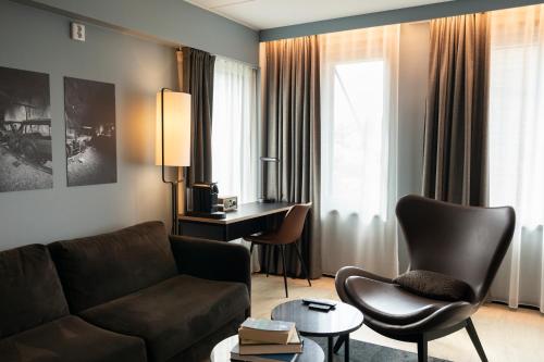 a living room with a couch and a desk at Home Hotel 1624 in Kongsberg