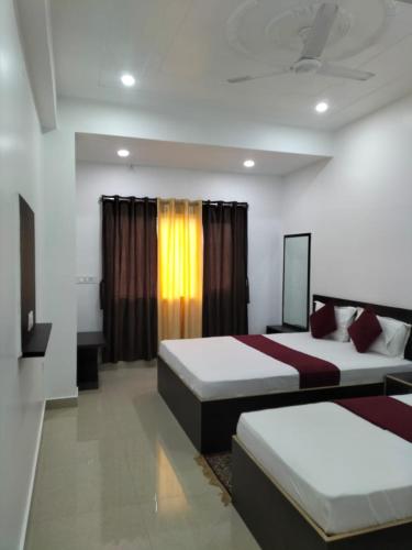 Una habitación de hotel con dos camas y una ventana. en Hotel Temple View, en Bodh Gaya