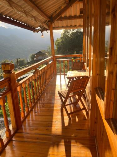 un porche de una cabaña con dos sillas en Bau's Sapa Homestay, 