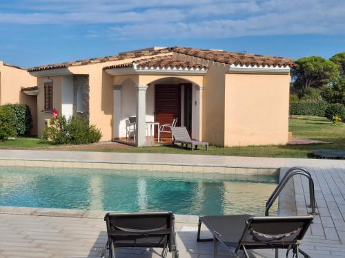 a house with a swimming pool and two chairs at Gallura Dream villas in Budoni