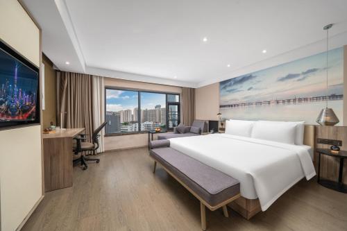 a bedroom with a large white bed and a desk at Mehood Lestie International Hotel Shenzhen Science and Technology Park Hi-Tech Central Metro Station Branch in Shenzhen