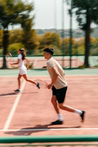 two people playing tennis on a tennis court at Mangia's Brucoli, Sicily, Autograph Collection in Brucoli