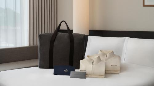 a hotel room with a bed with a black bag at Shilla Stay Yeosu Expo Station in Yeosu