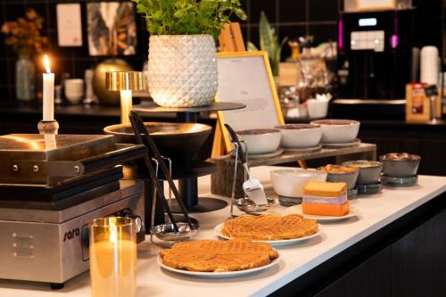 a buffet with cookies and other food on a counter at Home Hotel 1624 in Kongsberg