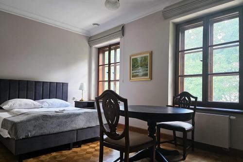 a bedroom with a bed and a table and chairs at Dwór Ostoya Zielony Kompleks in Jasionka