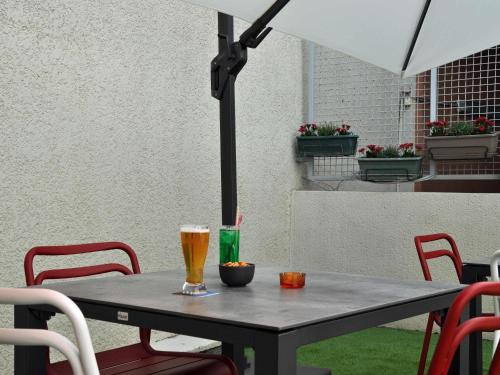 a table with two glasses of beer on it at ibis Toulouse Centre in Toulouse