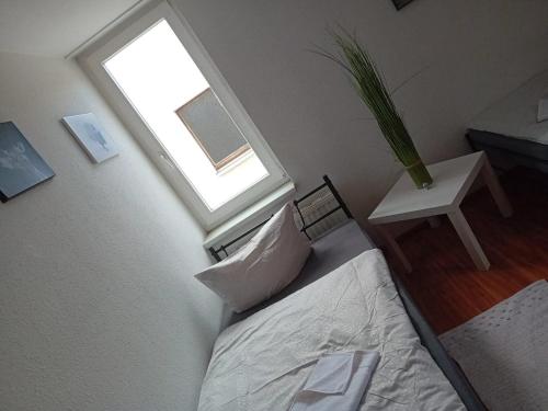 a bedroom with a bed with a window and a table at Stellas Monteurwohnungen in Crimmitschau