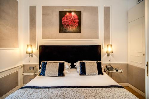 a bedroom with a bed and a painting on the wall at The Britannia Hotel in Rome
