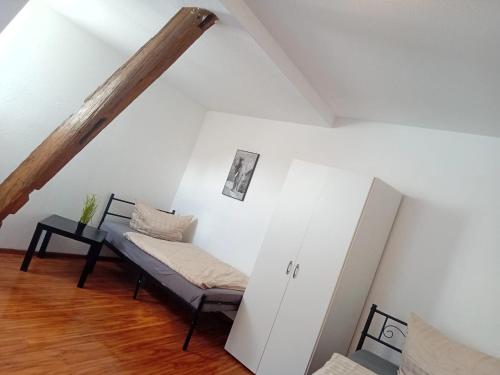 a living room with a bench and a white wall at Stellas Monteurwohnungen in Crimmitschau