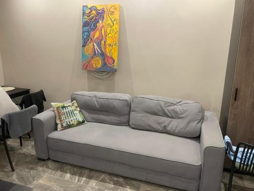 a couch in a living room with a painting on the wall at Номера in Dobrovelychkivka