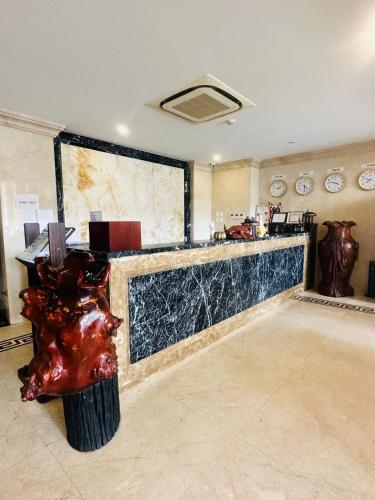 a lobby with a bar with a statue in front of it at Aaron Vientiane Hotel in Vientiane