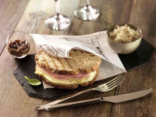 a sandwich on a black plate with a fork and knife at ibis Augsburg Hauptbahnhof in Augsburg