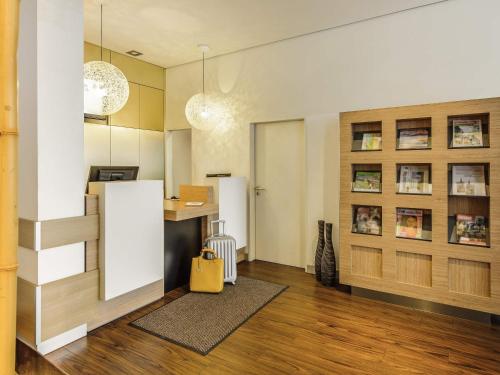 a living room with a desk and a yellow bag at ibis Bamberg Altstadt in Bamberg