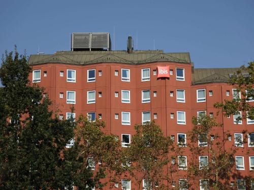 a red building with a air conditioner on top of it at ibis Frankfurt Centrum in Frankfurt/Main