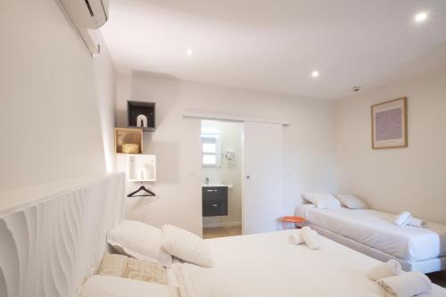 a white living room with two beds and a couch at GAB HOUSE - Lyon Bron - Eurexpo City Living Stay in Bron