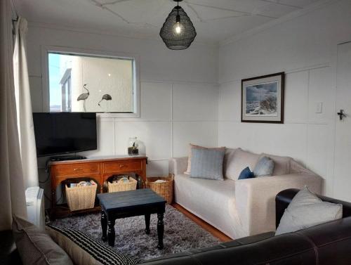 a living room with a couch and a flat screen tv at Nautical Nest in Bluff
