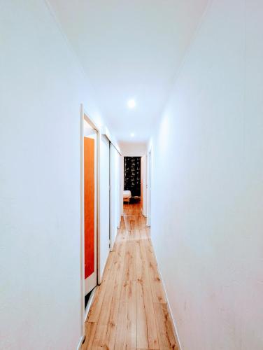 an empty hallway with white walls and wooden floors at Spacious and comfortable apart with terrace in downtown in Evry-Courcouronnes