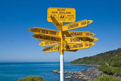 a yellow street sign with many signs on it at Nautical Nest in Bluff
