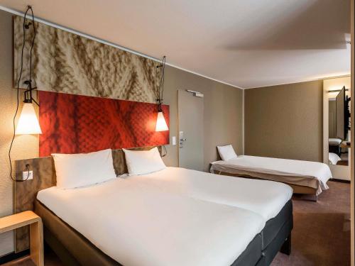 a hotel room with a bed and two beds at ibis Hotel München City in Munich