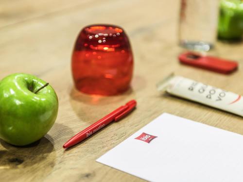 a green apple sitting on a table with a red pen at ibis Gent Centrum Opera in Ghent