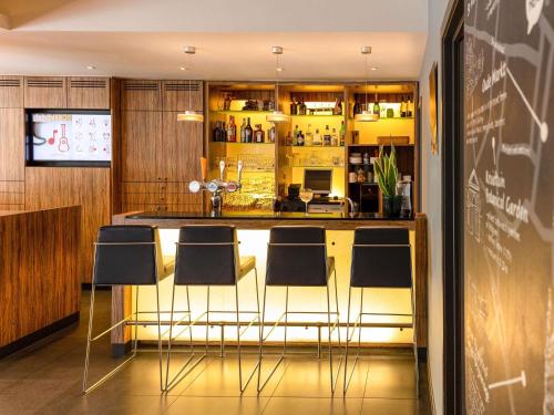 a bar in a restaurant with chairs around it at ibis Leuven Centrum in Leuven