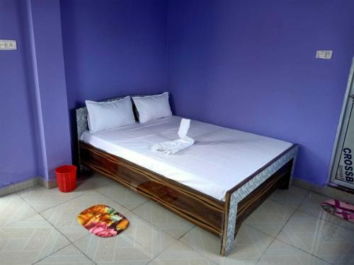 a bed in a purple room with a plate of fruit on the floor at HOTEL O PRIYAL INn in Bokāro