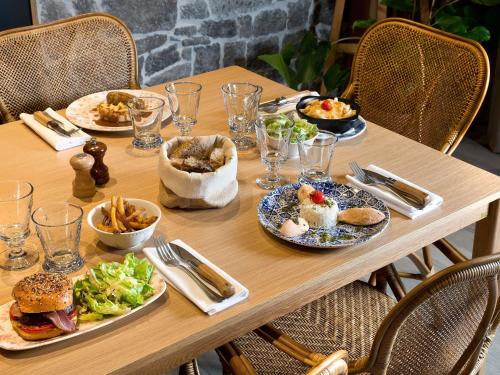 a wooden table with plates of food on it at ibis Vichy in Vichy