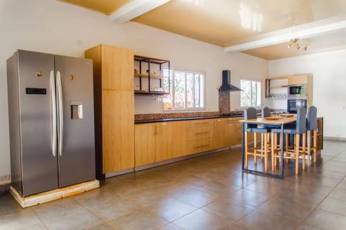 a kitchen with a stainless steel refrigerator and a table at Sumptuous Villa in Antsiranana with Private Pool in Antsiakambony