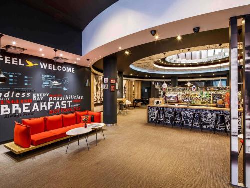 a lobby with a red couch and a bar at ibis Birmingham Centre New Street Station Hotel in Birmingham