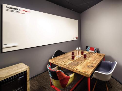 a meeting room with a table and a projector screen at ibis Birmingham Centre New Street Station Hotel in Birmingham