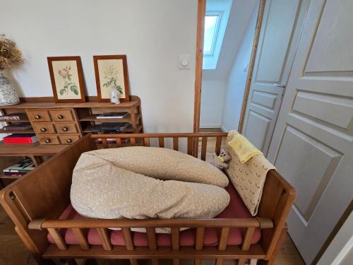a crib with a blanket in a room with a door at Maison en brique calme, nature, confort in Notre-Dame-du-Hamel
